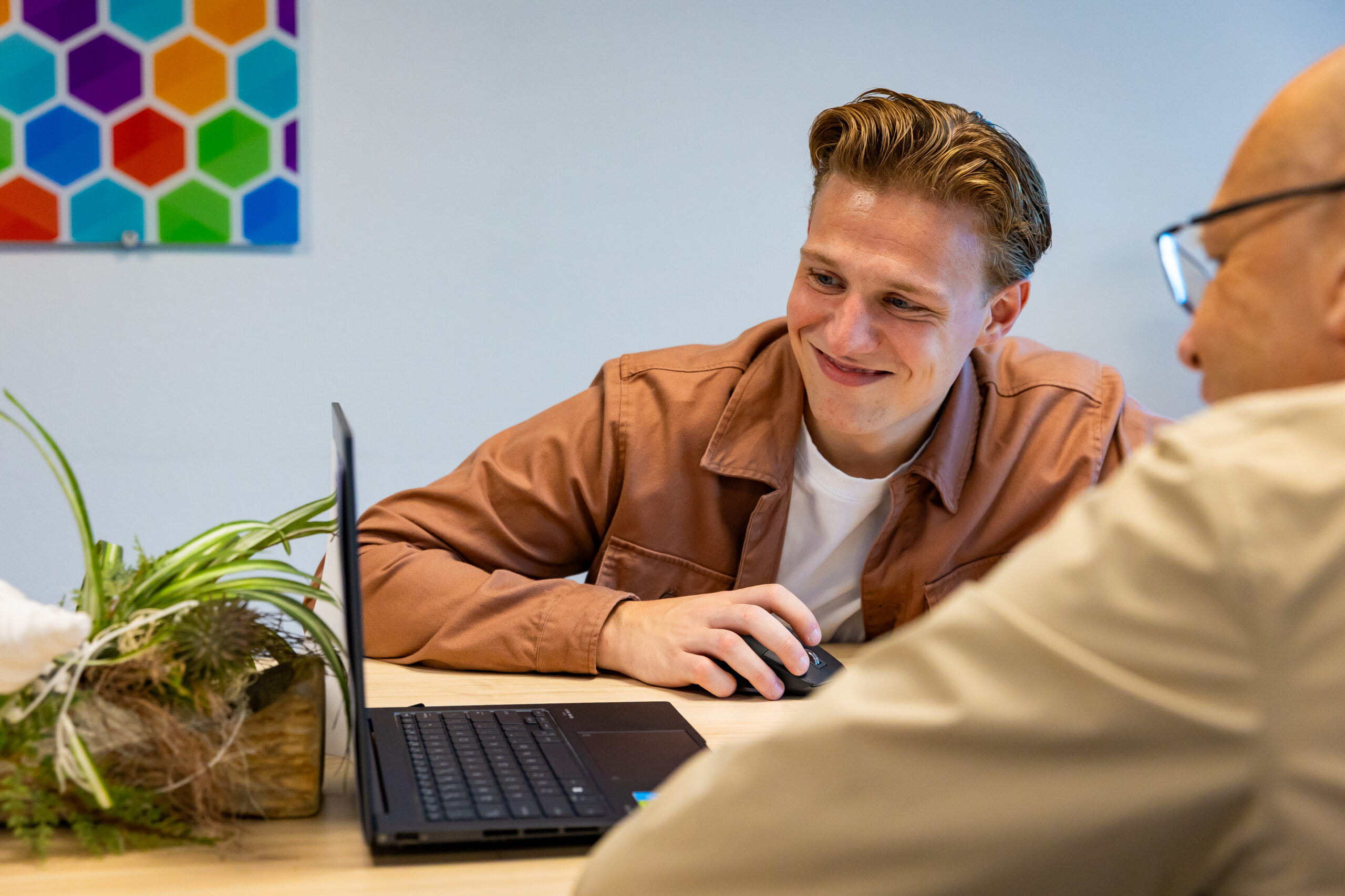 Medewerker van TEAM Website helpt een klant met het instellen van e-mail op de laptop.